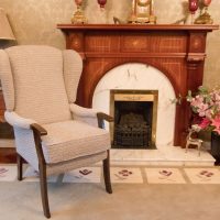 Cream fire side chair beside fireplace