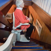 Elderly Woman going downstairs on stair lift