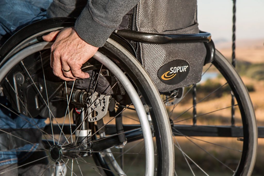 Wheelchair with man holding wheel rims