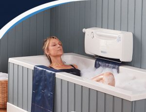 Lady lying in bath using bath lift